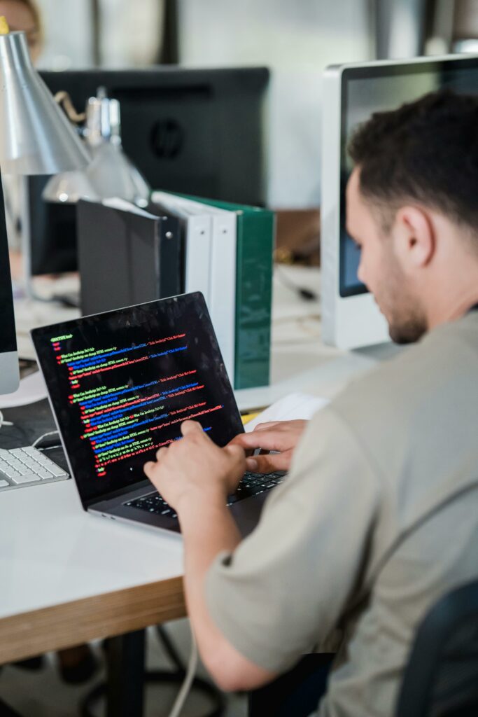 Top 5 Essential Tech Tutorials Every Beginner Should Know in 2026 Focused software developer typing code on a laptop in a modern office setting.